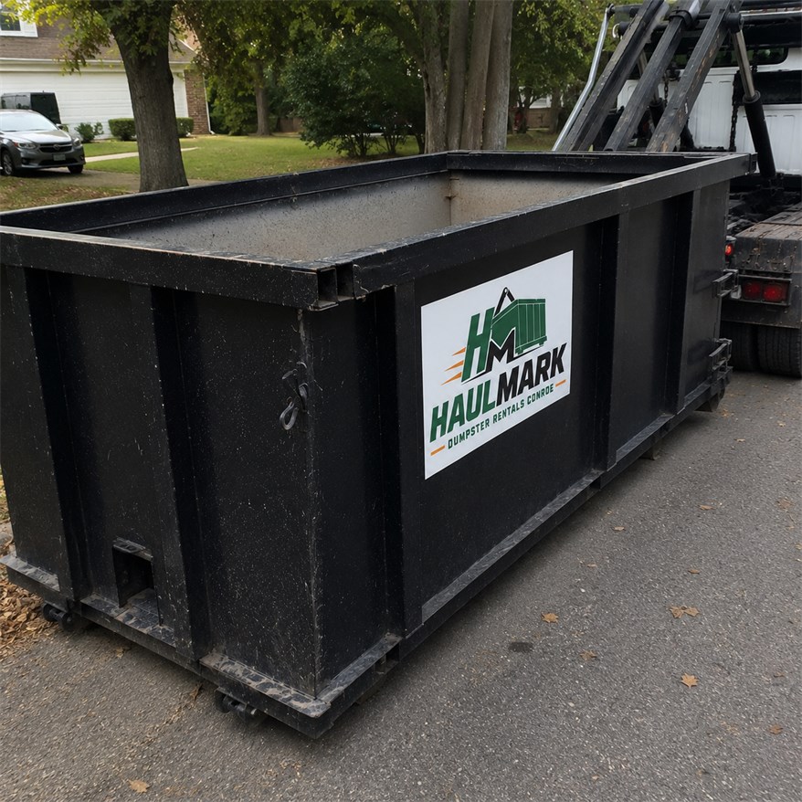Black Haulmark roll-off dumpster ready for a cleanup project in Conroe